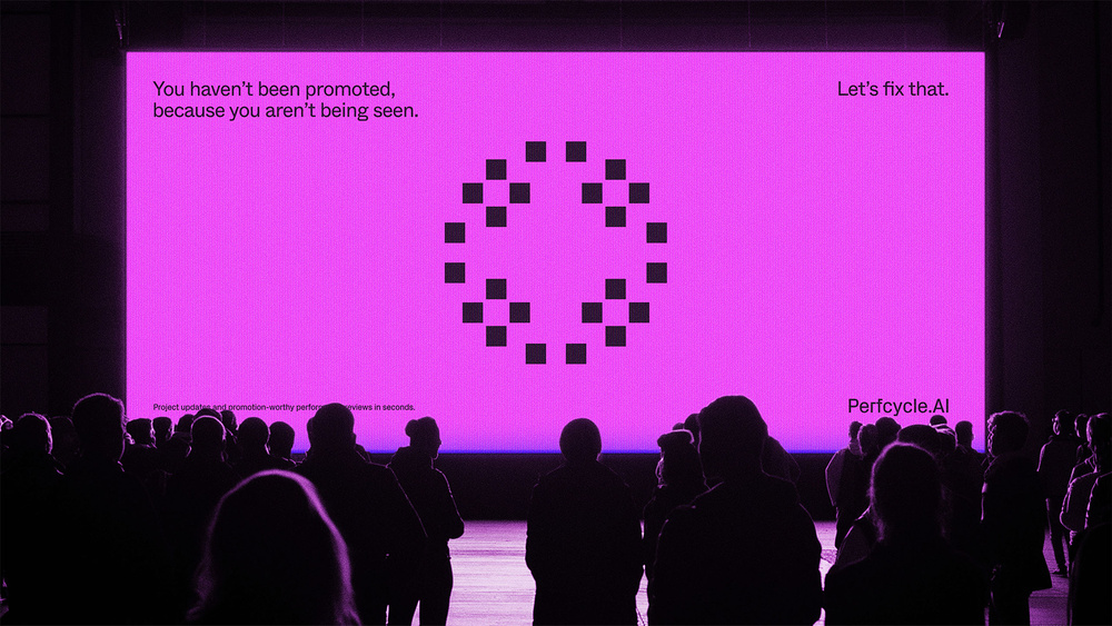 Crowd watching large pink screen with purple logo.